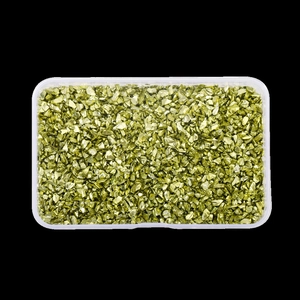 Macro view of gold irregular crushed glass stones in clear box for nail art and DIY crafts