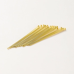 Macro-opname van vergulde platte kop T-spelden voor DIY-sieraden maken
