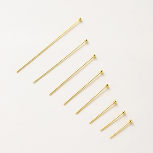 Detailed view of eight assorted lengths of gold-plated ball head pins for jewelry making