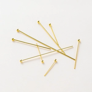 Detailed view of polished 14K gold-plated ball pins for handmade jewelry DIY projects
