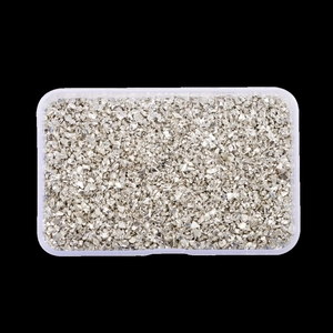 Detailed top view of irregular silver glitter glass stones for nail art in a plastic box