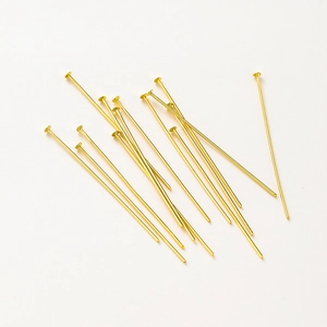 Macro-opname van 14K vergulde platkopstiften voor DIY-sieraden maken op witte achtergrond