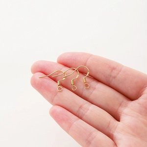 Vue macro de trois crochets d'oreilles dorés dans la paume pour détails DIY
