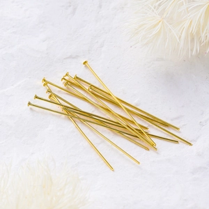 Macro-opname van 14K vergulde platte kopspelden voor DIY-sieraden op witte steen