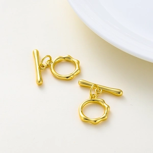 Makroaufnahme von zwei Sets unregelmäßiger vergoldeter OT-Knebelverschlüsse für Schmuck