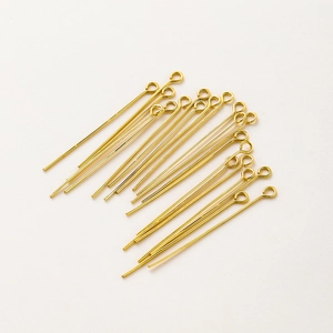 Close-up of golden eye pins for DIY jewelry making featuring smooth metal finish
