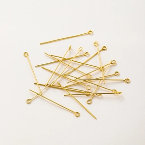 Close-up of golden eye pins for jewelry making with polished 18K gold plated finish