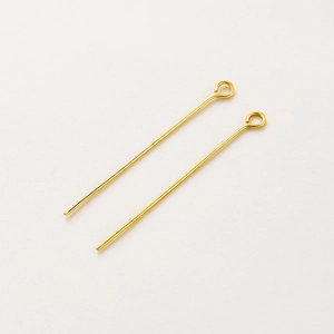Detail shot of two gold-plated brass eye pins for DIY jewelry making and beading