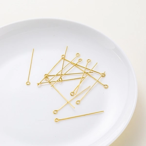 Macro shot of 18K gold plated 9-pins for DIY jewelry making on white plate