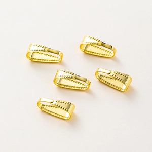 Macro detail van 14K vergulde knijpbeugels met decoratieve kralen voor DIY-sieraden