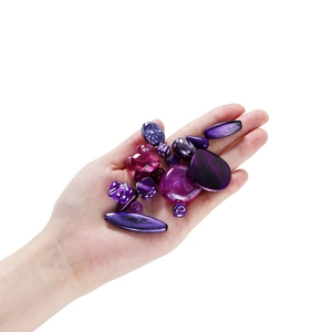 Hand hält lila Acrylperlen-Mix in verschiedenen Formen für DIY Schmuckherstellung