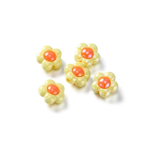 Detailed macro view of five yellow acrylic flower beads with shiny iridescent coating