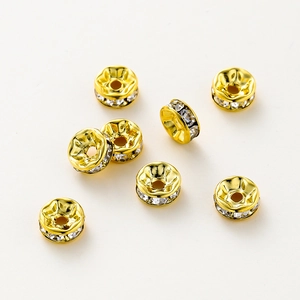 Vista macro de cuentas espaciadoras rondelle chapadas en oro 14K con cristales blancos