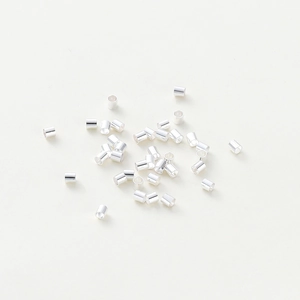 Gros plan de perles cylindriques en argent poli pour la création de bijoux DIY et sertis