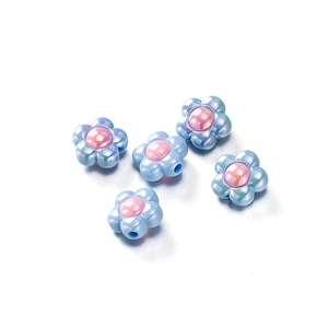 Macro shot of iridescent blue acrylic flower beads with pink centers for jewelry making
