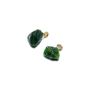 Detail of dark green translucent zongzi pendants with gold rings for DIY jewelry making