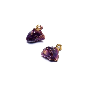 Detailed close-up of two purple enamel fish charms with golden loops for DIY jewelry