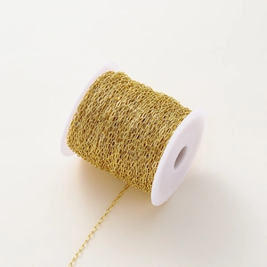 Close-up of 18K gold plated oval link chain on a white spool for DIY jewelry making