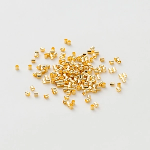 Vue macro de perles à écraser cylindriques plaquées or pour la création de bijoux DIY