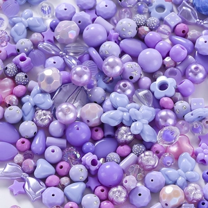 Nahaufnahme violetter Acryl-Bastelperlen mit Sternen, Blumen und funkelnden Schmucksteinen