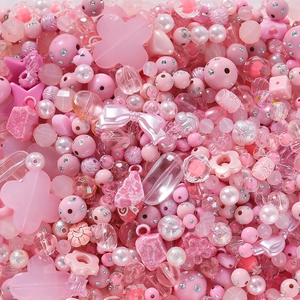 Makroaufnahme von rosa Acrylperlen in Stern-, Blumen- und Herzform für DIY-Schmuck