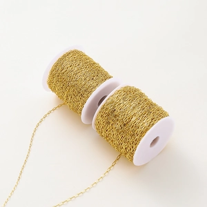 Detail of 18K gold-plated oval link chain on white spools for DIY jewelry making