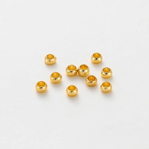 Macro shot of 10 gold-plated spacer beads for DIY jewelry making on white background