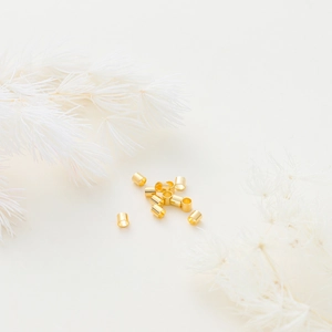 Gros plan sur des perles d'espacement dorées 14K et accessoires de bijoux
