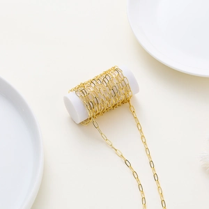 Macro detail of high-shine 18K gold-plated oval paperclip chain on white display
