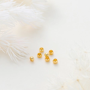 Close-up of polished 14K gold plated spacer beads for DIY jewelry making with pine decor