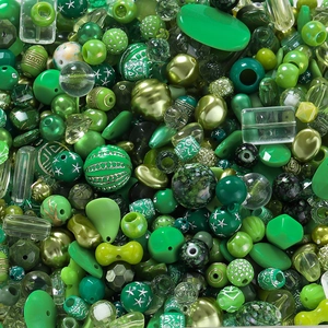 Nahaufnahme grüner Acrylperlen für DIY-Schmuck mit verschiedenen Formen und Texturen