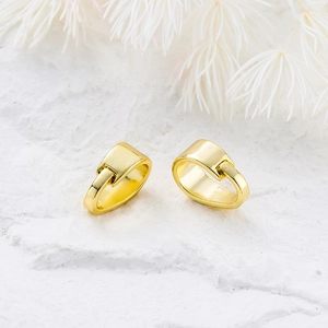 Close-up of polished 14K gold plated clasp showing hinge detail on stone surface