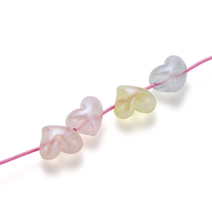 Macro detail of pearlescent heart-shaped acrylic beads for DIY jewelry making