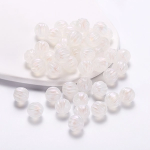 Macro shot of white iridescent pumpkin beads with ribbed texture for DIY jewelry making