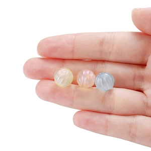 Macro detail of iridescent pearlescent acrylic beads in yellow, pink and blue for DIY jewelry