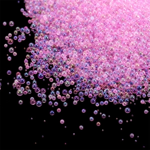 Aurora pink and purple mini glass bubble beads for DIY resin art on black background