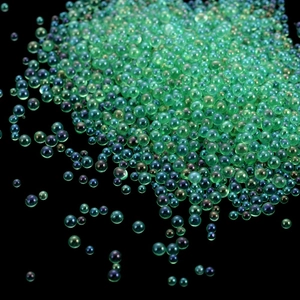 Macro shot of iridescent green bubble beads for nail art and resin crafts decoration