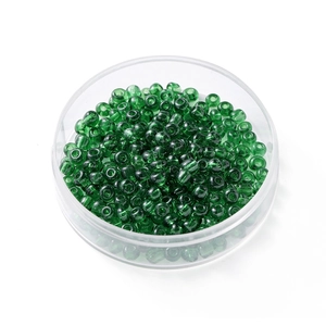 Détail de perles de rocaille en verre vert de 4 mm dans une boîte de rangement ronde