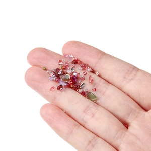 Macro shot of colorful irregular mini crystal glass stones for DIY crafts held in hand