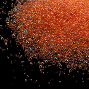 Macro view of amber iridescent glass bubble beads for DIY nail art and resin crafts