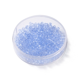 Gros plan de perles de rocaille en verre bleu clair de 4 mm dans une boîte ronde