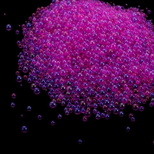 Macro shot of colorful purple and pink translucent glass bubble beads for DIY resin nail art