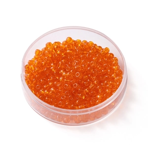 Vue macro de perles de rocaille orange transparent de 4mm dans une boîte en plastique