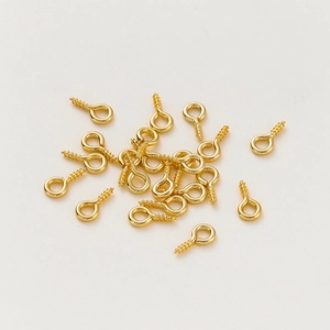 Close-up of gold-plated eye pins with screw threads for DIY pendant jewelry making