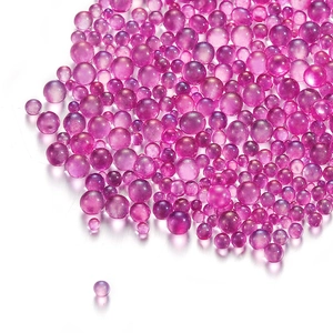 Macro shot of assorted size pink and purple iridescent bubble glass beads for DIY nails