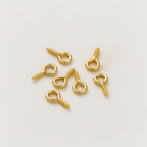 Detail of 14K gold plated screw eye pins for DIY jewelry making and small pendant crafts