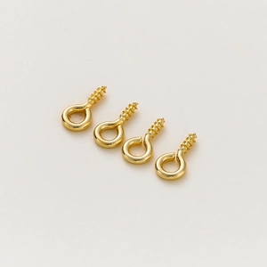 Detailed close-up of four gold-plated metal eye pins with threaded ends for jewelry DIY