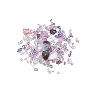 Macro shot of mixed iridescent crystal stones and white pearls for DIY nail art and crafts