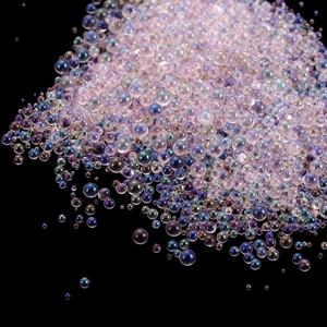 Macro detail of mixed size iridescent glass bubble beads for DIY resin and nail art