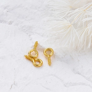 Macro detail of 14K gold plated screw eye pins for DIY jewelry making pendant findings